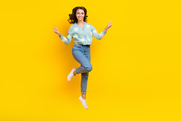 Fototapeta na wymiar Full body photo of overjoyed cheerful lady jumping hands fingers demonstrate v-sign isolated on yellow color background