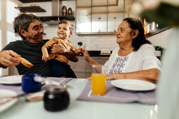 Happy grandparents having breakfast with their grandson
