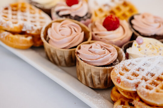 s&uuml;&szlig;e Cupcakes mit rosa topping Nahaufnahme am Kuchenbuffet einer Hochzeitsfeier