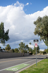 Road sign on a metal post and painted symbol on asphalt to mark a designated lane for bicyclists