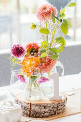 Blumenstrauß in Vase als Tischdekoration auf Hochzeitsfeier mit Tiger-Lilie und Dahlie und Tischnummer eins