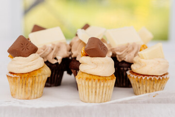Cupcakes und Muffins mit Vanillecreme Topping und Schokoladenstück als Deko im Kuchenbuffet