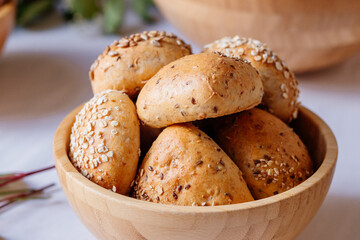 gesunde Mehrkornbrötchen vom Bäcker bei Frühstücksbuffet in schöner Holzschüssel für eine gute Ernährung