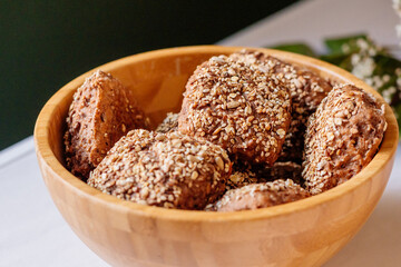Mehrkornbrötchen vom Bäcker bei Frühstücksbuffet in schöner Holzschüssel für eine gesunde Ernährung