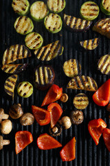 Grilled vegetables in flat lay. Hot grill pan surface with cooked zucchini, red bell pepers and mushrooms