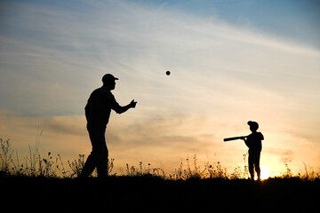 silhouette child with parent playing baseball concept