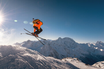 winter vacation at the ski resort. skier quickly fly in the air doing a stunt heli-skiing on the...