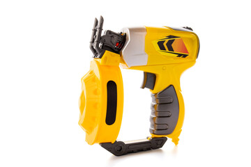 Yellow plastic toy pneumatic nail gun isolated on white background
