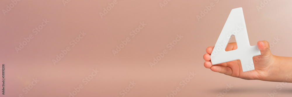 Fototapete number four in hand. Hand holding white number 4 on red background with copy space. Concept with number four. Birthday 4 years, fourth grade, four day work week