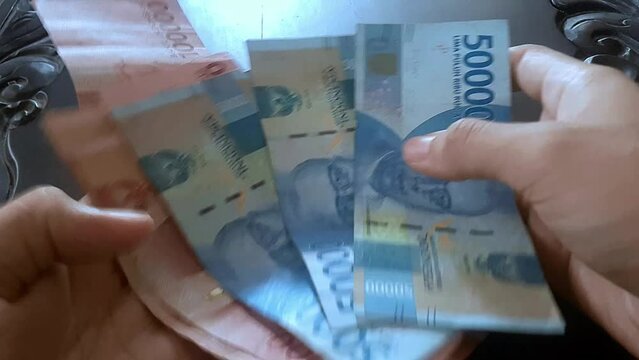 counting money for necessities, Rupiah Indonesia 