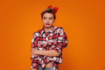 Young girl with shocked,surprised expression, isolated on orange studio background.