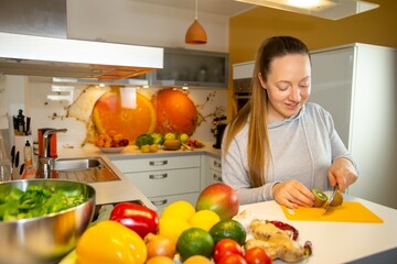 Vegan Ernähren: Junge Frau schneidet eine Kiwi