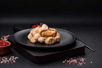 Delicious chicken slices baked with spices and herbs on a round ceramic plate
