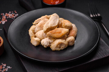 Delicious chicken slices baked with spices and herbs on a round ceramic plate