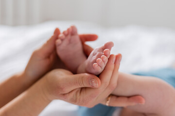 mom holds baby's small feet close-up