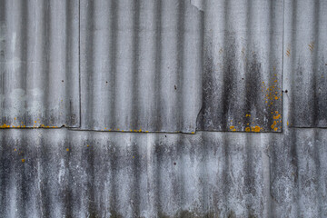 wall made of gray wavy asbestos slates. Weathered old grunge background texture.