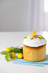 Easter table with traditional dessert of cake with marshmallow glaze and spring decoration on white background with copy space. Happy Easter greeting card. Spring postcard for Easter holidays.
