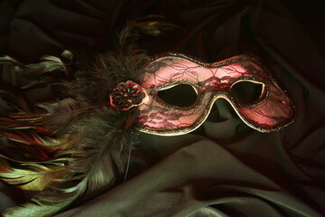 carnival mask with red light on black background