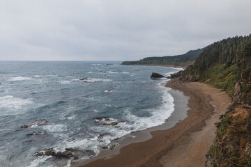 Picturesque Cape Velikan on the shore of the Sea of ​​Okhotsk in the Far East of Russia, Sakhalin Island. Picturesque coastal cliffs and the sea.