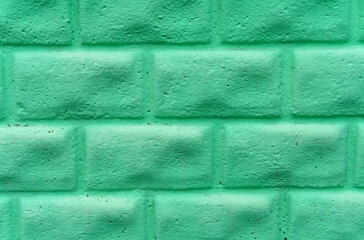 The texture of a concrete wall made to look like a stone and painted green
