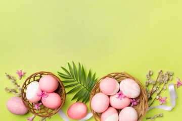 Pink Easter eggs with decor on color background, top view