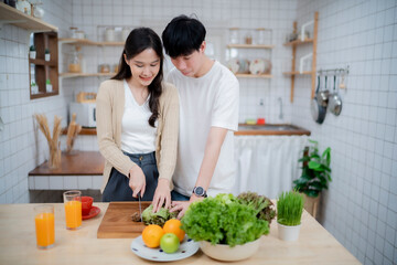 Couple of love making salad together at kitchen with smile of hapiness, happy family concept.