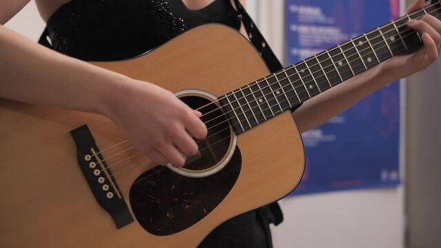 Female singer playing guitar backstage