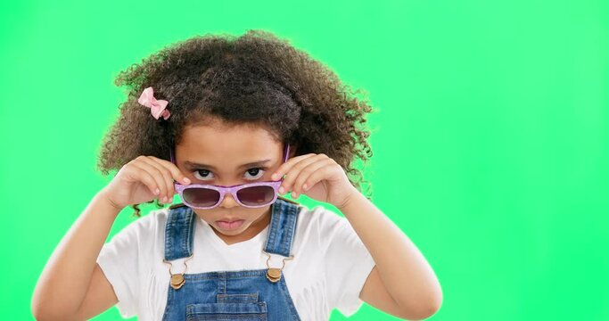 Portrait, green screen and a girl looking over her glasses in studio to ask a question with attitude. Kids, fashion and eyewear with an adorable little female child on chromakey mockup for style