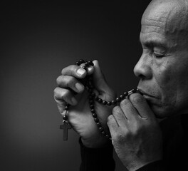 Fototapeta na wymiar praying to god with hands together Caribbean man praying with black background with people stock photo
