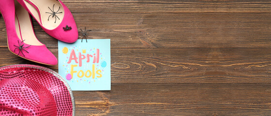 Paper with text APRIL FOOLS, female shoes, spiders and hat on wooden background with space for text - Powered by Adobe