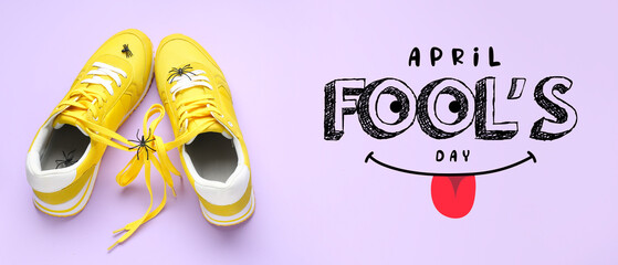 Sneakers with tied shoe laces and spiders on lilac background. April Fools' Day celebration