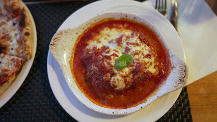 Lasagna on plate. Tasty Food meal with cheese. Closeup of lasagna with red sauce at restaurant