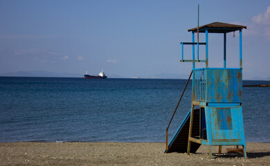 Old and rusty lifeguard tower on the beach. Vintage lifeguard tower, blue and moldy. Retro lifeguard concept. Copy space and text space, landscape.
