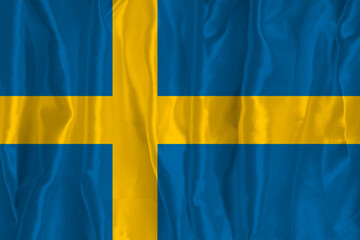 The flag of Sweden on a silk background is a great national symbol. Texture of fabrics The official state symbol of the country