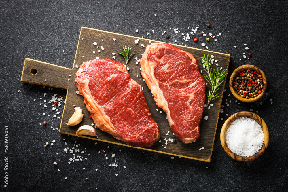 Wall mural Beef steak. Raw beef meat at black. Top view with copy space.