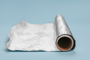 Roll of aluminium foil on color background