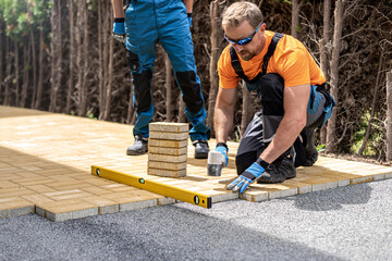 Laying of interlocking paving. 