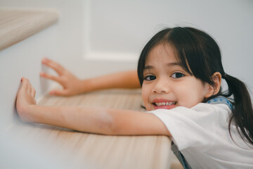 Happy little Asian girl having fun at the stairs.