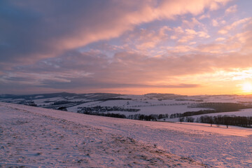 Winter panorama, landscape fields, meadows, trees. Winter morning of a new day. Orange purple sunset landscape. Panoramic view.