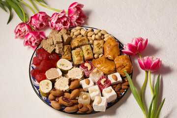 Still life of oriental sweets on a light background with tulips