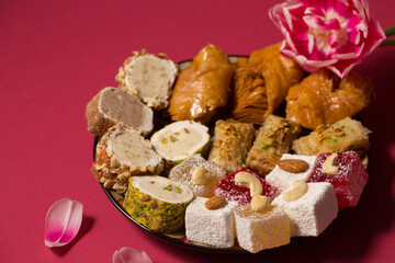 oriental sweets on a pink background with pink tulip