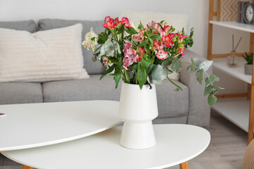 Vase with bouquet of beautiful alstroemeria flowers on table in living room