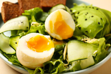 Plate of delicious salad with boiled eggs and avocado, closeup