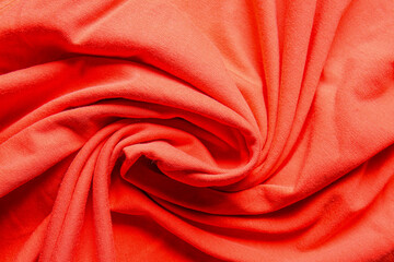 Closeup view of coral crumpled fabric texture as background