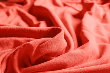 Closeup view of coral crumpled fabric texture as background