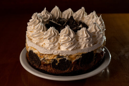 chocolate cake with white American cream. decorated with American cream and oreos: horizontal image