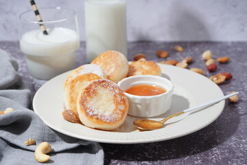 Plate with tasty cottage cheese pancakes and jam on table