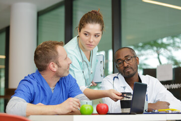 doctors checking laptop while having lunch