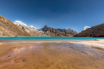 Beach of beautiful Gokyo Lake with the village and Cholatse in the background