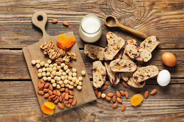 Delicious biscotti cookies and board with nuts on wooden background